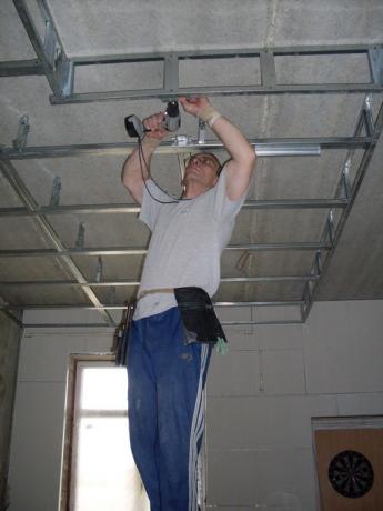 La photo montre l'installation d'un faux plafond.