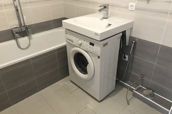 Machine à laver sous l'évier dans la salle de bain