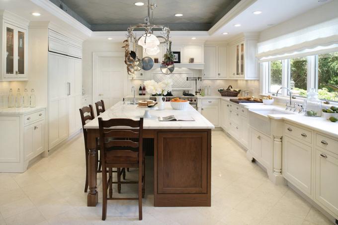 Les carreaux sont gris pour mettre en valeur une cuisine blanche, tandis que les cloisons sèches blanches correspondent au style général de la pièce.