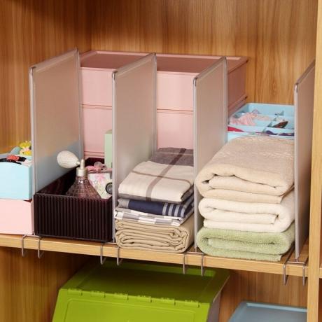 Aider à former un séparateur pile de vêtements soignée, foulards, serviettes. / Photo: gdeo.ru